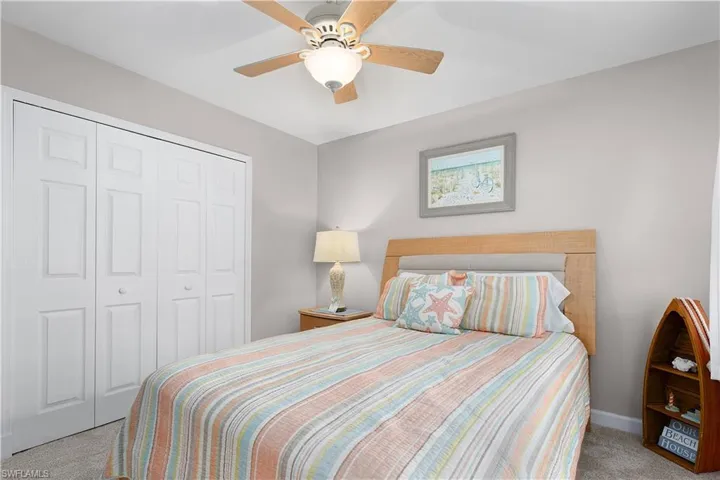 Carpeted bedroom with a closet and a ceiling fan
