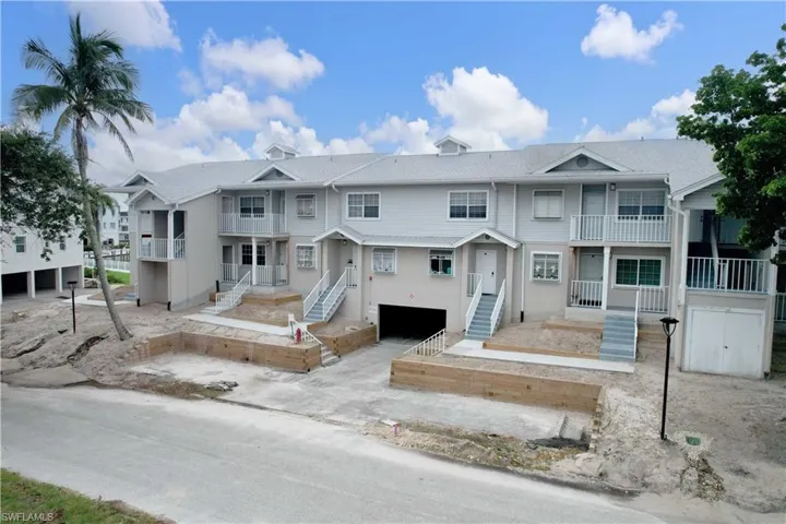View of front facade with an attached garage, a residential view, a balcony, and stairs