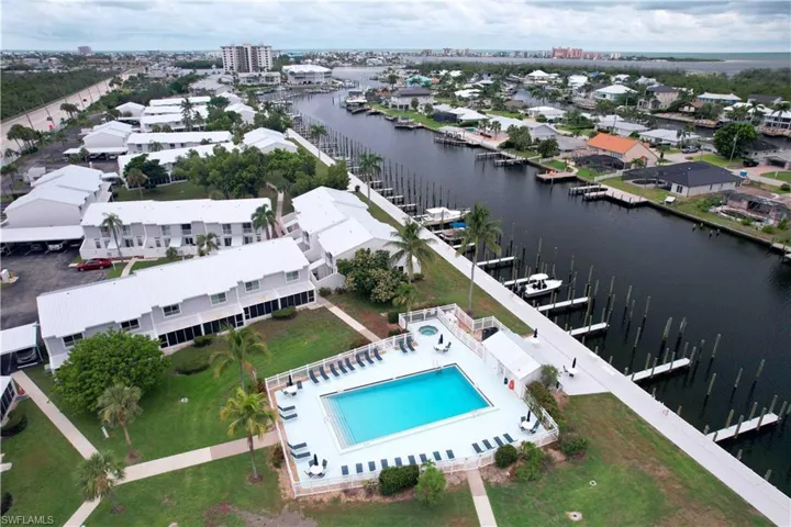 Bird's eye view of a nearby body of water and a pool area