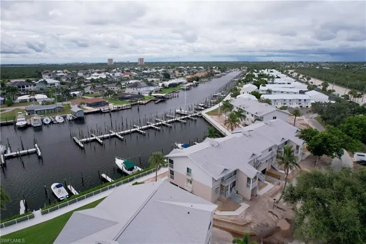 Aerial perspective of suburban area featuring a large body of water and a marina