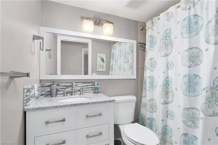 Full bath with vanity and a shower with curtain