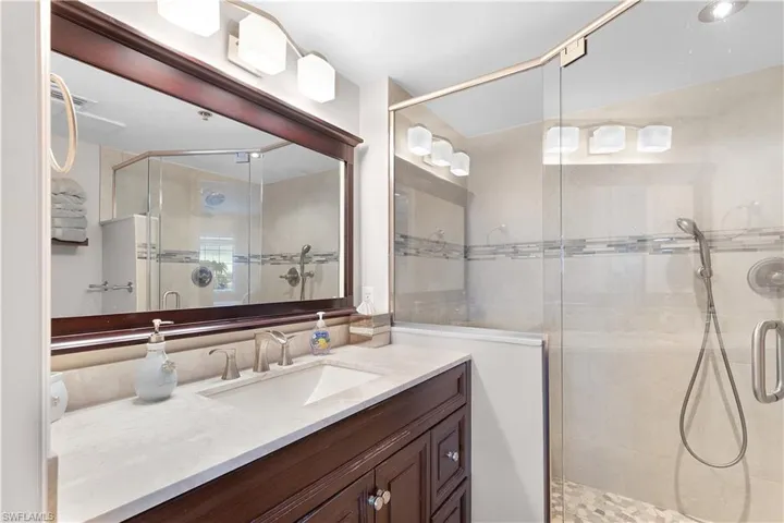 Full bathroom with vanity and a shower stall