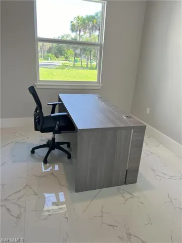 Neutral painted walls, large window with white trim, and white tile flooring with gray veining