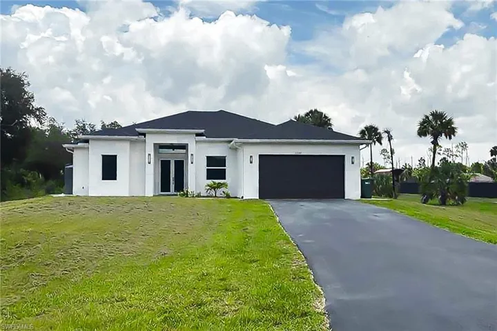 Contemporary single-story residence featuring a white stucco exterior and a dark shingle roof