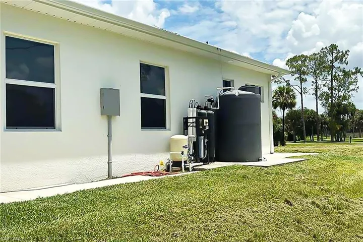 Exterior water treatment system with a large storage tank, situated on a concrete pad