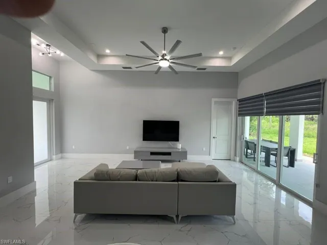 Spacious living area featuring high ceilings with tray detailing and recessed lighting