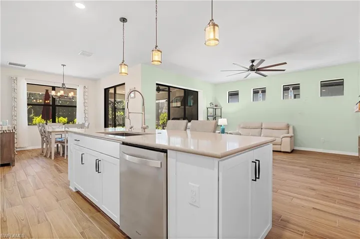 Kitchen with white cabinets, dishwasher, and light wood finished floors