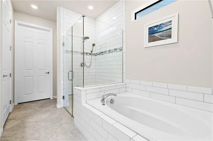Bathroom featuring a garden tub, a shower stall, recessed lighting, and light tile patterned floors