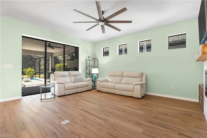 Living room featuring a sunroom, ceiling fan, and light wood finished floors