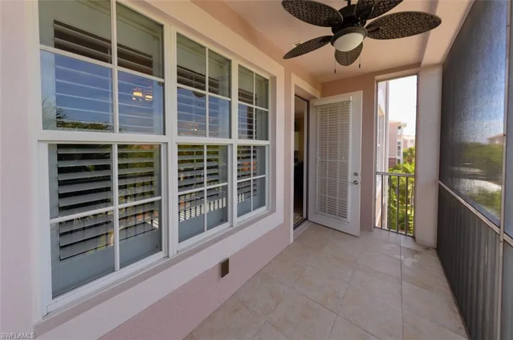 Covered and screened Lanai with view of Landscaped area and trees.