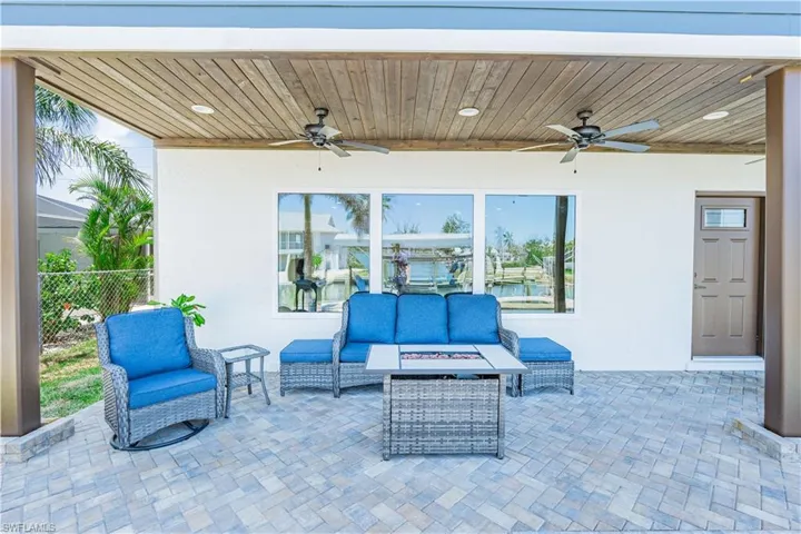 Covered patio featuring paver flooring, a wood-finish ceiling with recessed lighting, and two ceiling fans