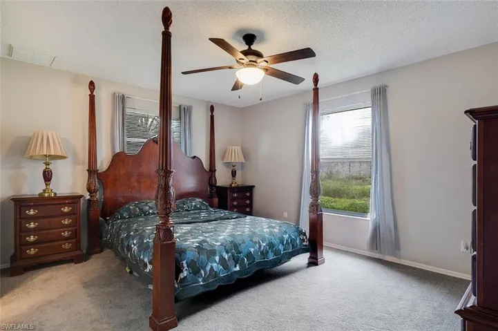 Bedroom featuring carpet flooring, a textured ceiling, and a ceiling fan