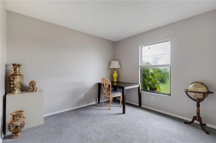 Office area with light carpet and a textured ceiling