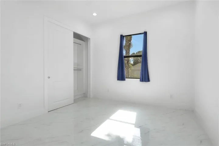 Unfurnished bedroom featuring light marble finish floors and recessed lighting