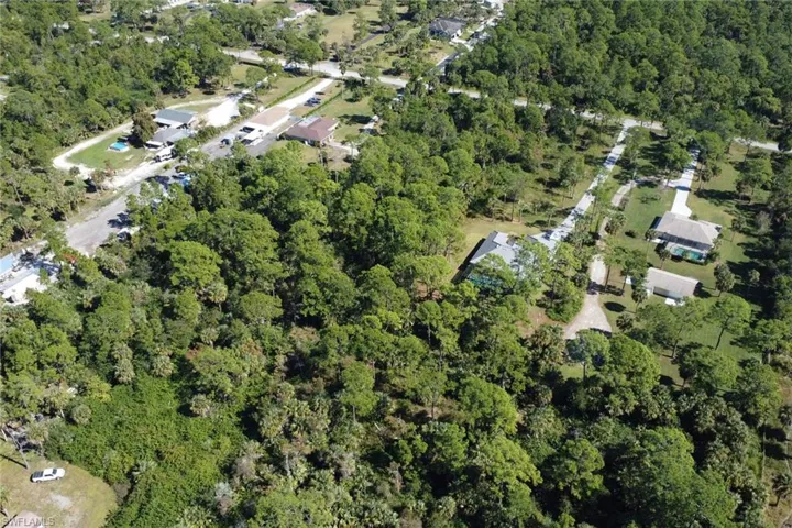 Aerial view of property's location featuring a heavily wooded area