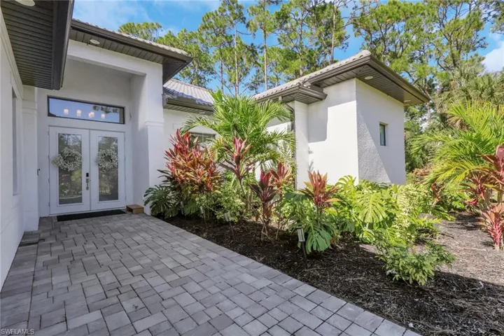 Entrance to property featuring stucco siding, french doors, and a tiled roof
