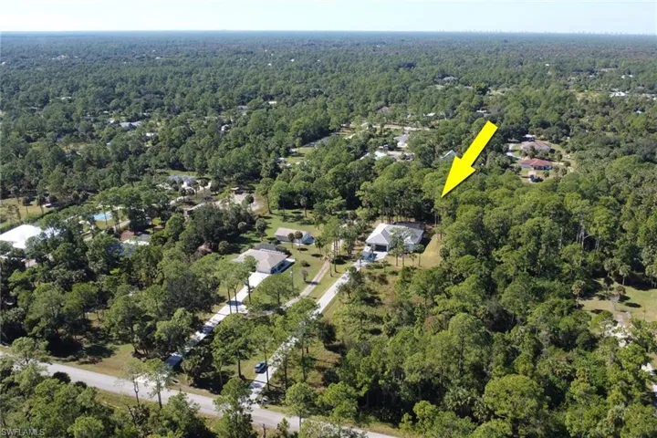 Aerial view of property's location with a heavily wooded area