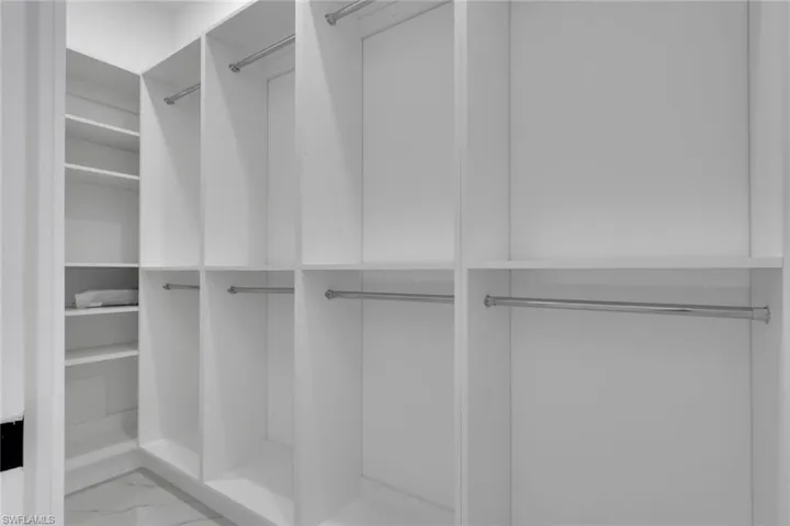 Spacious closet featuring marble look tiles