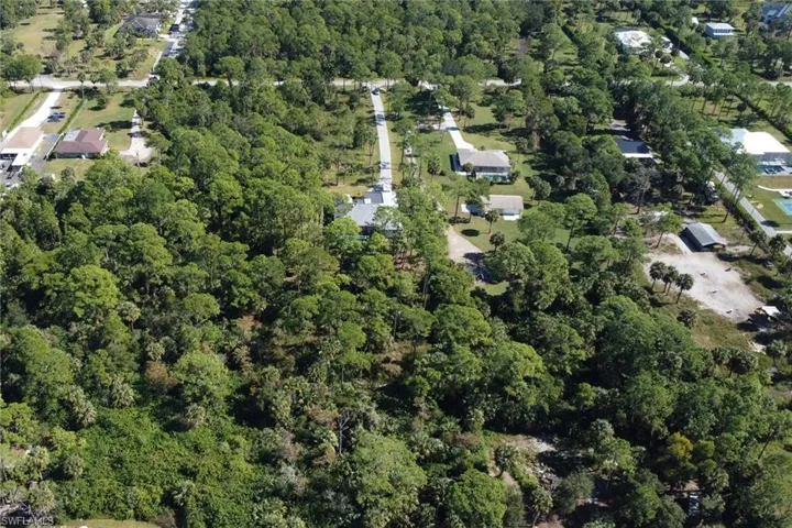 Aerial view of property's location featuring a heavily wooded area