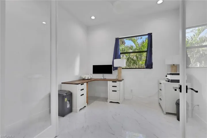 Home office featuring recessed lighting and light marble finish floors