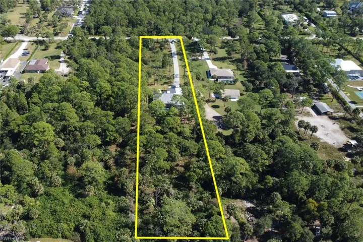Aerial view of property's location featuring property parcel outlined and a forest