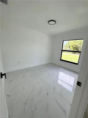 Bedroom with light marble finish flooring and a closet