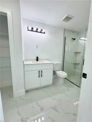 Unfurnished bedroom with light marble finish flooring, a ceiling fan, and a closet