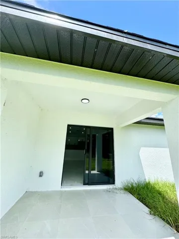 Doorway to property featuring a patio and stucco siding