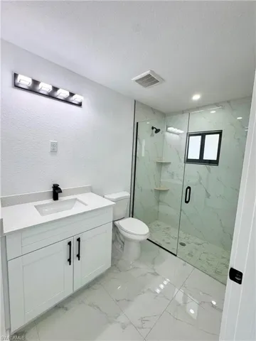 Unfurnished bedroom featuring light marble finish floors and a closet