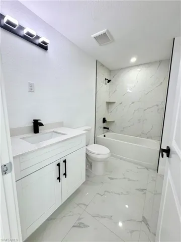 Kitchen with white cabinetry, pendant lighting, light marble finish floors, recessed lighting, and a ceiling fan