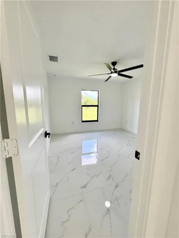 Empty room featuring light marble finish floors and baseboards