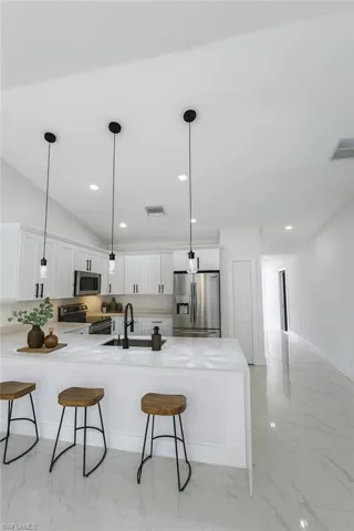 Hallway featuring light marble finish floors and recessed lighting