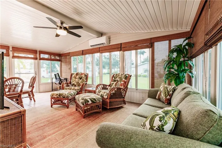 Sunroom / solarium with a wall mounted air conditioner, wooden ceiling, ceiling fan, and lofted ceiling