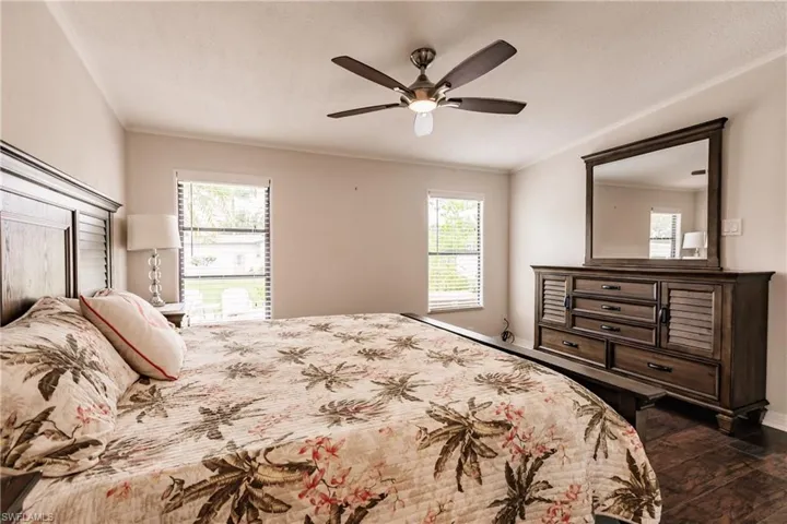Bedroom featuring crown molding, dark hardwood / wood-style flooring, and ceiling fan
