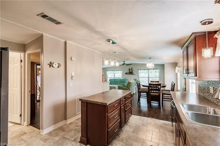 Kitchen featuring light tile patterned flooring, a center island, sink, and pendant lighting