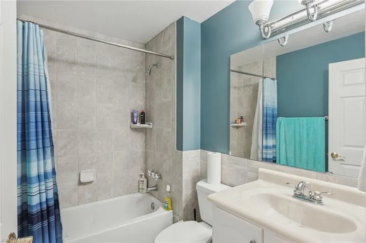 Full bath featuring toilet, shower / tub combo with curtain, and vanity