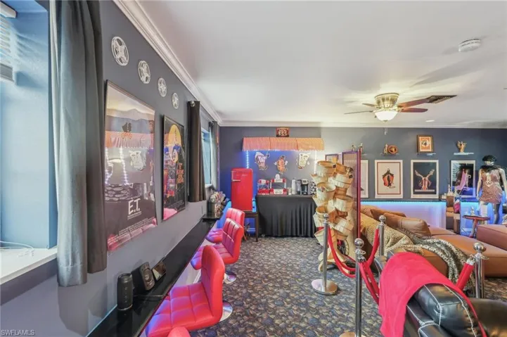 Living area featuring carpet, crown molding, and a ceiling fan
