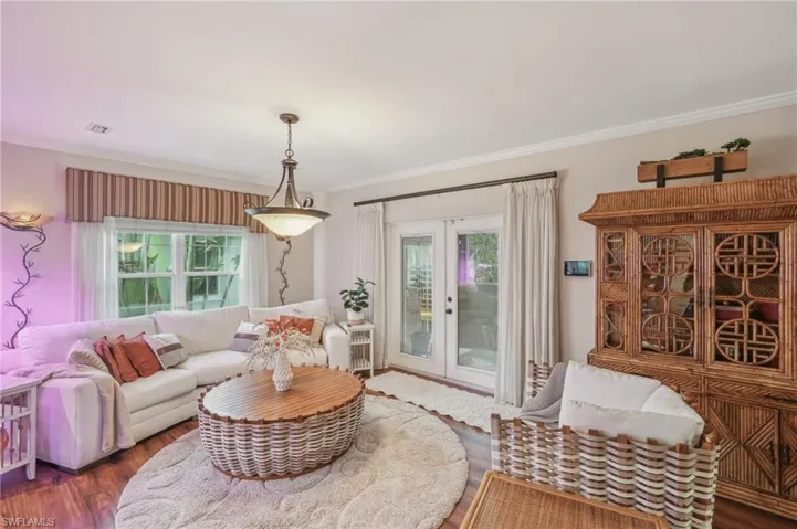 Living room featuring crown molding, visible vents, french doors, and wood finished floors