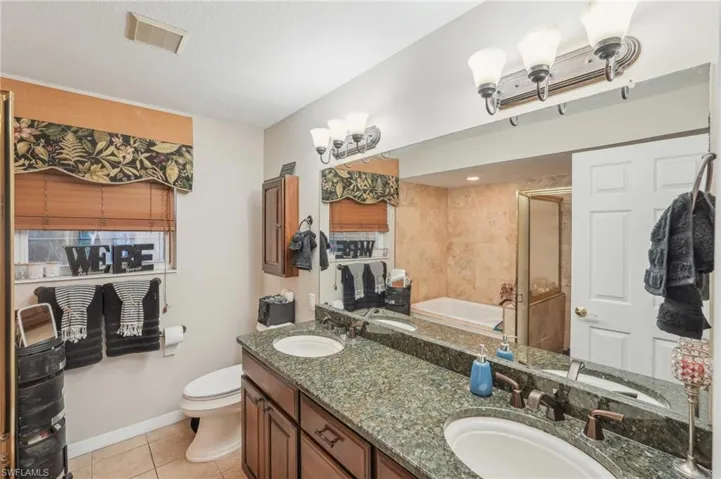 Full bathroom featuring a sink, visible vents, tile patterned floors, and an enclosed shower
