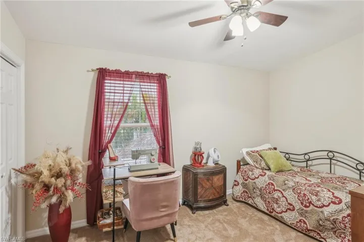 Bedroom with carpet flooring, baseboards, and a ceiling fan