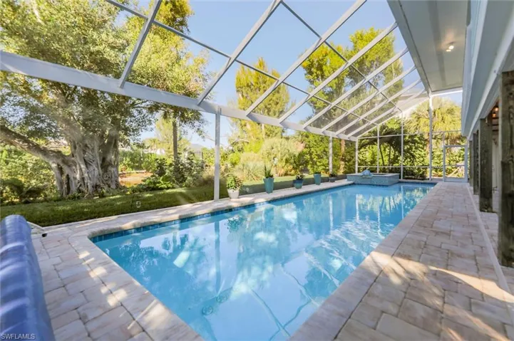 Outdoor pool with a lanai, a sunroom, and a patio