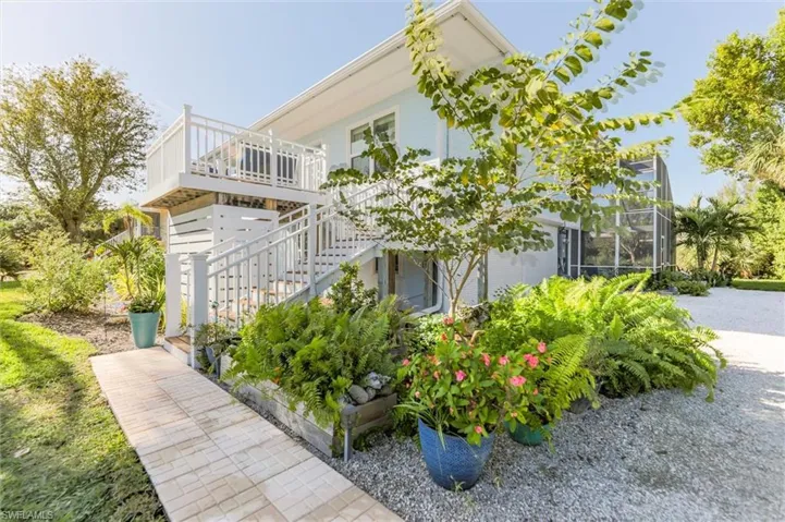 View of property exterior with stairway, a lanai, and a balcony