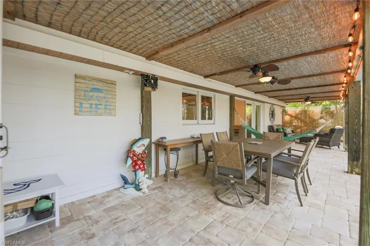 View of patio with outdoor dining area and ceiling fan