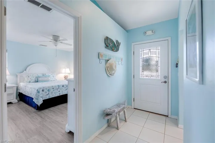Doorway with baseboards and a ceiling fan