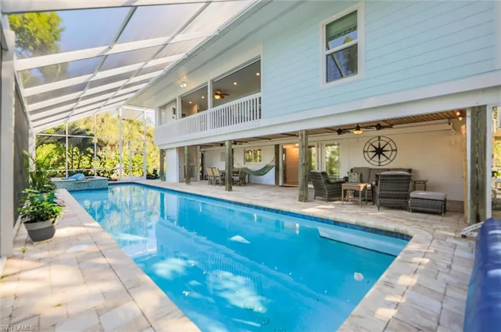 View of pool featuring a patio area, outdoor lounge area, a lanai, a pool with connected hot tub, and a balcony