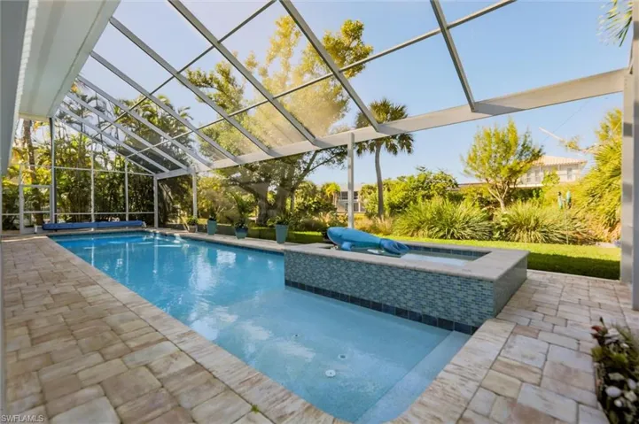 Swimming pool with a lanai, a jacuzzi, a patio area, and a sunroom