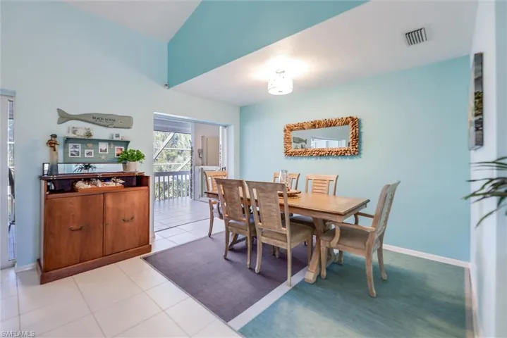 Tiled dining area with lofted ceiling