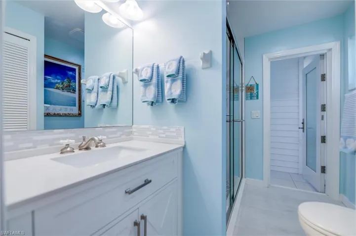 Full bath featuring vanity, backsplash, and a stall shower