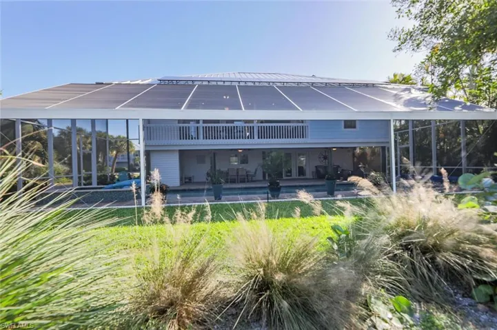 Back of house featuring a patio, a sunroom, an outdoor pool, and a metal roof