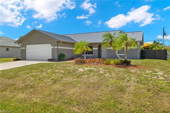 View of front of home featuring a garage and a front lawn